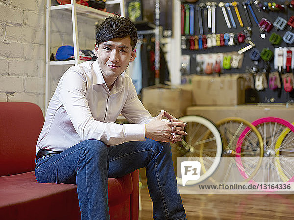 Portrait of young man sitting in bike shop