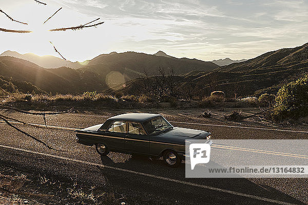 Junger Mann fährt Oldtimer auf Roadtrip in der Wüste  Los Angeles  Kalifornien  USA