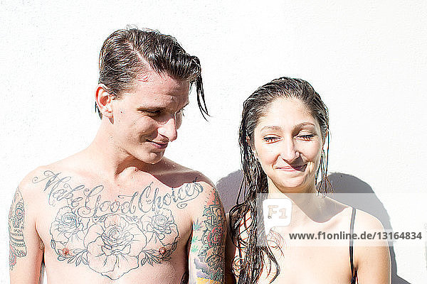 Junges Paar mit Tätowierungen und nassem Haar