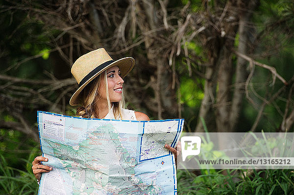 Young woman with map in forest