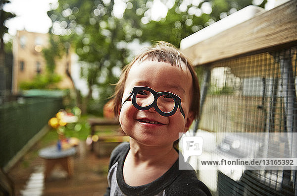 Junge mit lustiger Brille im Garten