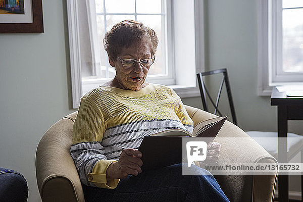Senior woman reading book at home