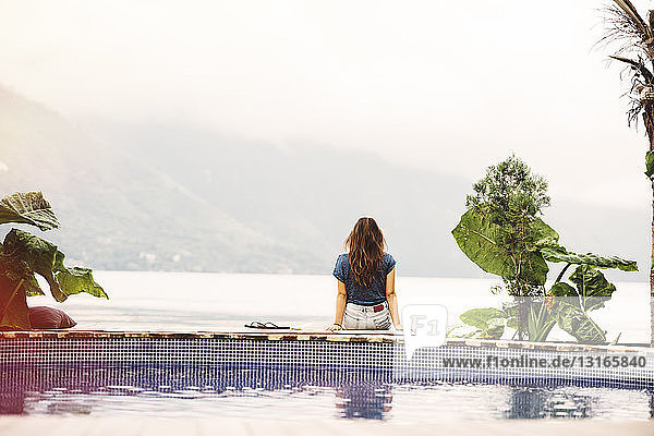 Junge Frau sitzt am Rand eines Pools  San Pedro  Atitlan-See  Guatemala