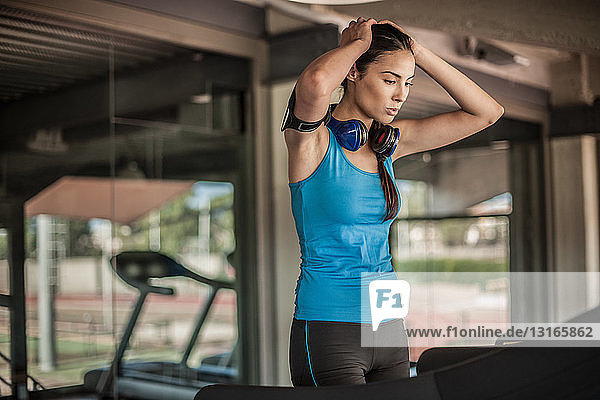 Junge Frau ruht sich im Fitnessstudio aus