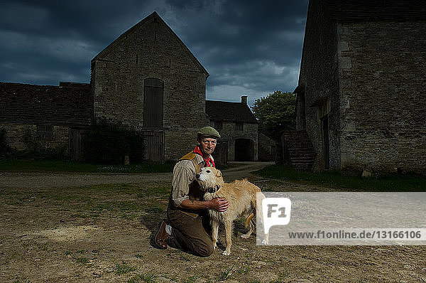 Porträt eines reifen  traditionellen Bauern und seines taumelnden Hundes
