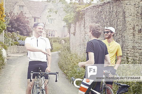 Cyclists stopping by stone wall  Cotswolds  UK