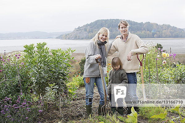 Porträt von Ehepaar und Sohn beim Graben eines biologischen Gartens  Orust  Schweden