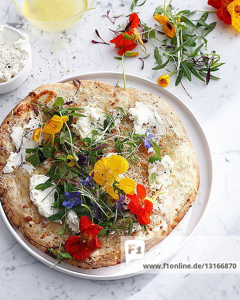 Pizzateller mit Käse und Blumen