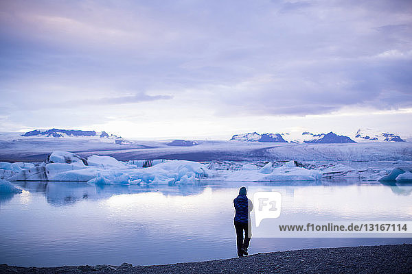 Rückansicht einer mittleren erwachsenen Frau in der Silhouette am Gletschersee Jokulsarlon  Island