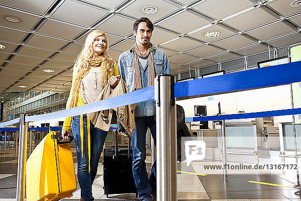 Paar rollendes Gepäck im Flughafen