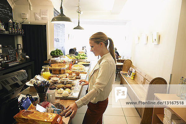 Weiblicher Kunde wählt Kuchen an der Café-Theke