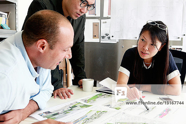 Team von drei Architekten diskutiert Ideen für den Entwurf im Büro