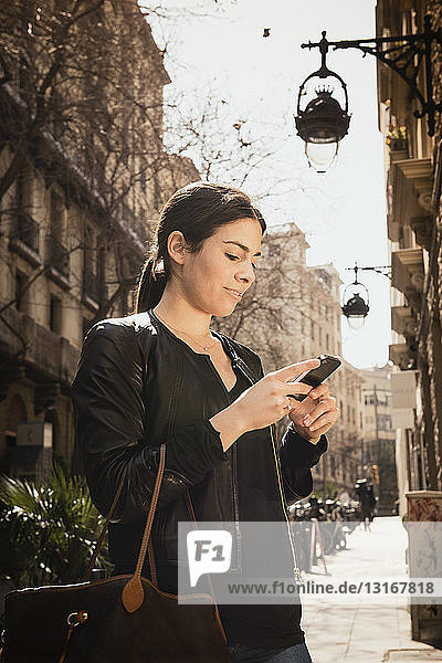 Woman using smartphone on street  El Born  Barcelona  Spain