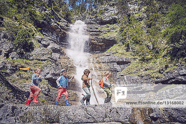 Gruppe von Kindern erkundet den Wasserfall