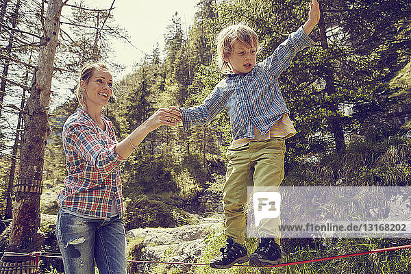 Junge balanciert auf Seil mit Hilfe der Mutter  Ehrwald  Tirol  Österreich
