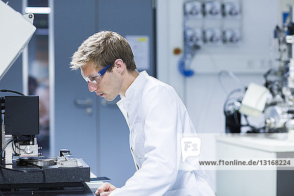 Male scientist monitoring equipment in laboratory