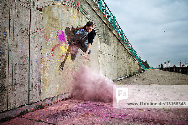 Parkour athlete experimenting with movement and powder paint at Balcombe Viaducts Sussex United Kingdom