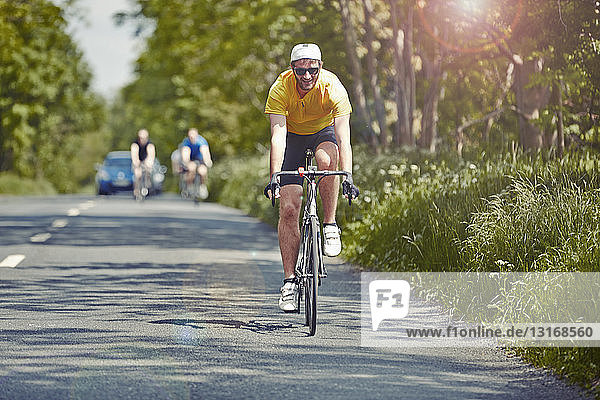 Cyclists riding on single carriageway Cotswolds UK