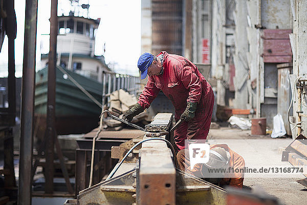 Workers doing maintenance in shipyard workshop