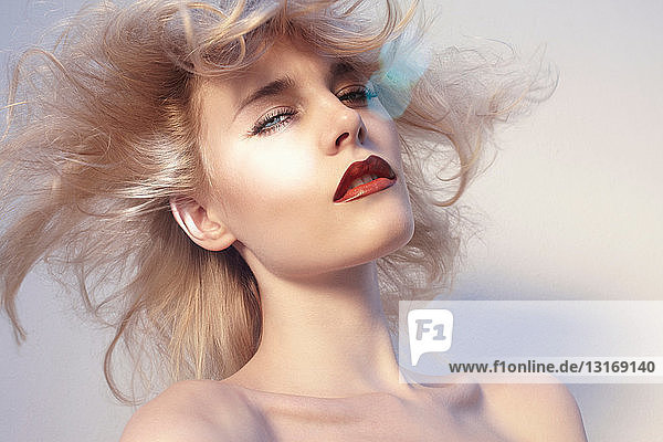 Junge Frau mit windgepeitschten blonden Haaren  Porträt