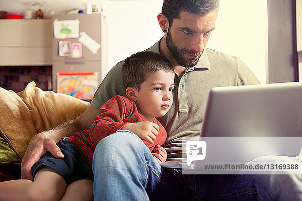 Vater und Sohn benutzen Laptop