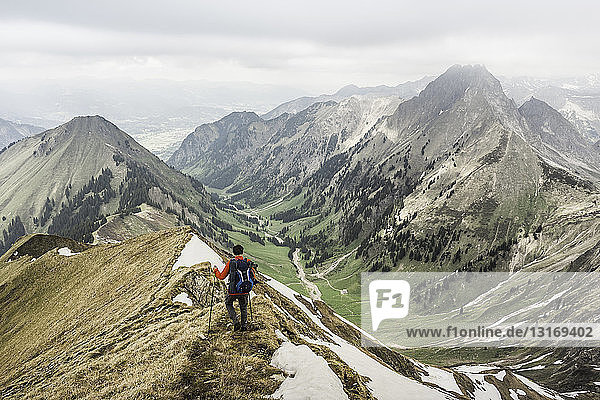 Young man mountain trekking down ridge in Bavarian Alps  Oberstdorf  Bavaria  Germany