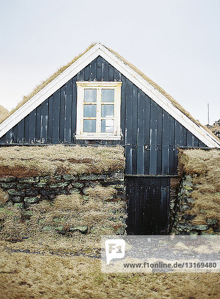 Schwarze Holzhütte mit Torfdach  Island