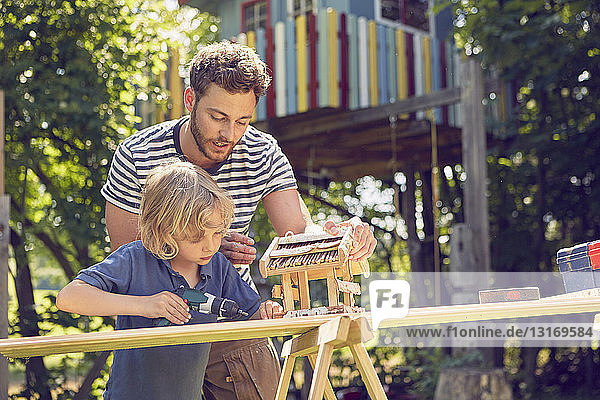 Vater und Sohn machen gemeinsam Holzarbeiten im Freien