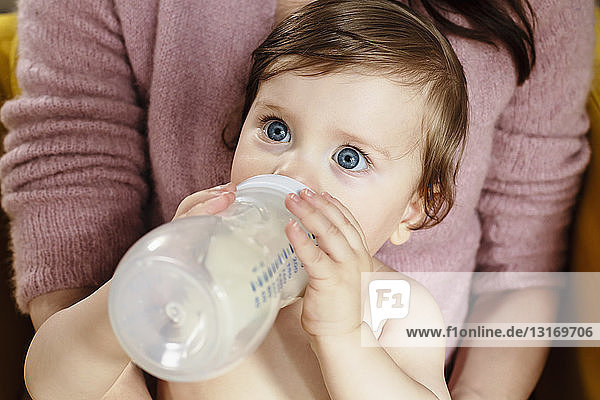 Säugling trinkt Milch aus der Flasche
