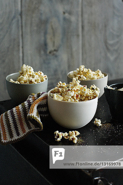 Schalen mit aromatisiertem Popcorn auf dem Tisch