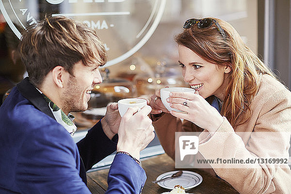 Couple drinking coffee at sidewalk cafe  London  UK