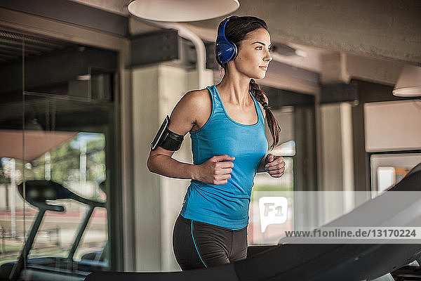 Junge Frau läuft auf dem Laufband