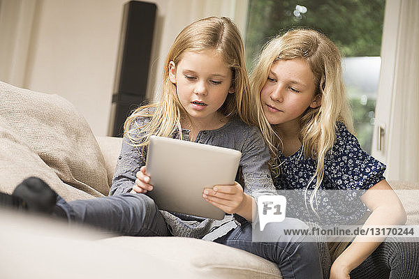 Two sisters using digital tablet