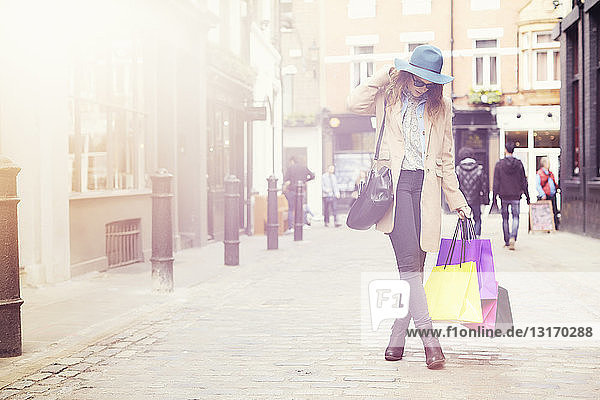 Porträt einer eleganten jungen Frau mit Einkaufstaschen London UK