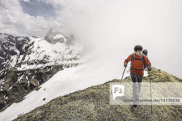 Young man mountain trekking along ridge in Bavarian Alps  Oberstdorf  Bavaria  Germany