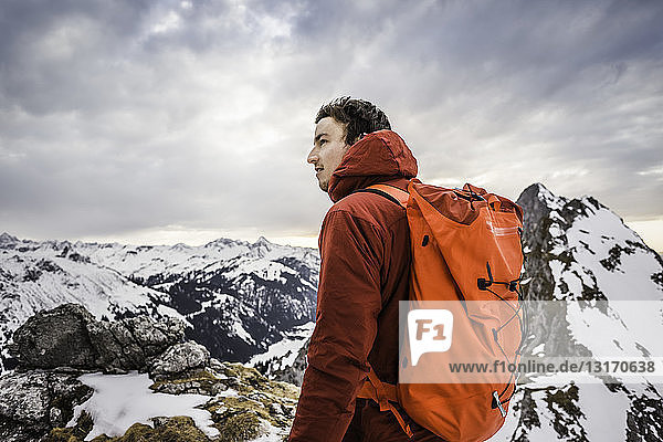 Hiker looking at snow capped mountain range  Kellenspitze  Tannheim mountains  Tyrol  Austria