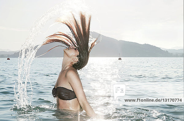 Junge Frau,  die ihren Kopf zurückwirft Lake Attesee,  Österreich