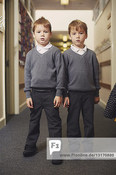 Porträt von Grundschüler-Zwillingen auf dem Schulkorridor