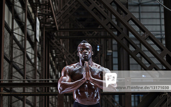Bare-chested athlete in prayer position