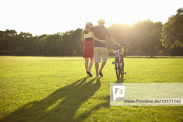 Paar schlendert beim Radfahren im Park