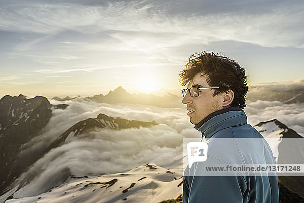 Junger männlicher Bergwanderer beim Blick über die Wolken  Bayerische Alpen  Oberstdorf  Bayern  Deutschland