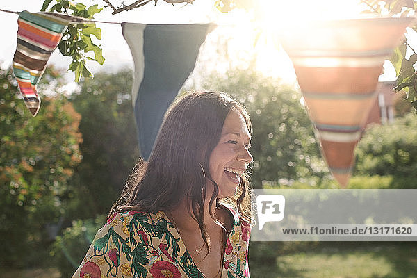 Smiling mid adult woman looking away while standing in backyard