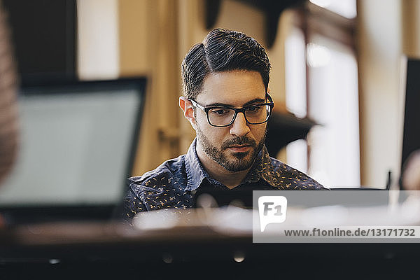 Businessman wearing glasses while working in creative office