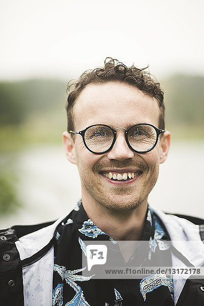 Portrait of smiling mid adult man wearing eyeglasses during dinner party in backyard