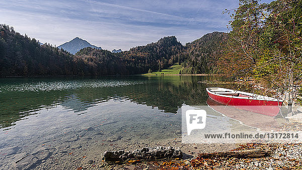 Deutschland  Bayern  Ostallgäu  Füssen  Alatsee  Boot am Seeufer im Herbst