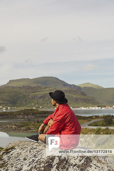 Young man sitting on rock in Vesteralen island  Lapland  Norway
