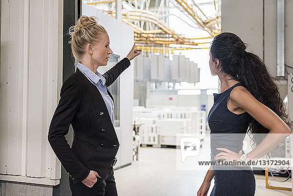 Two women talking in modern factory