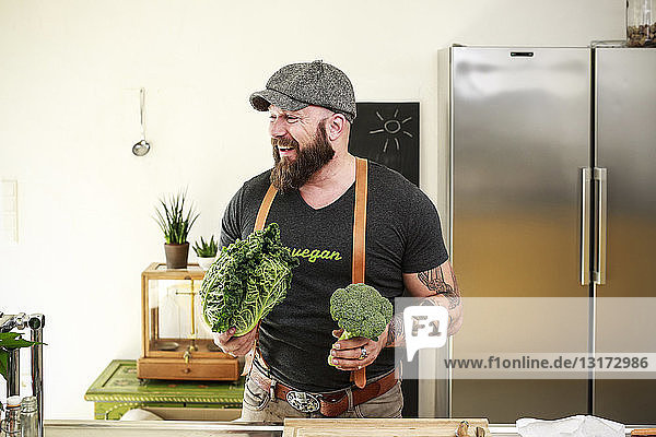 Veganer wählt Gemüse in seiner Küche