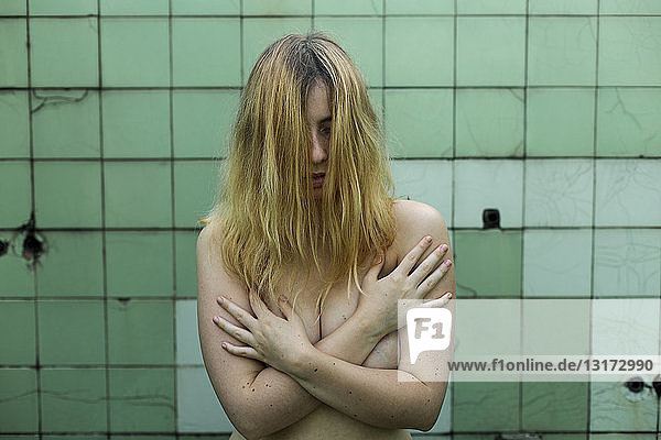 Nude woman showing emotions in bathroom  feminism  abuse and violence against women