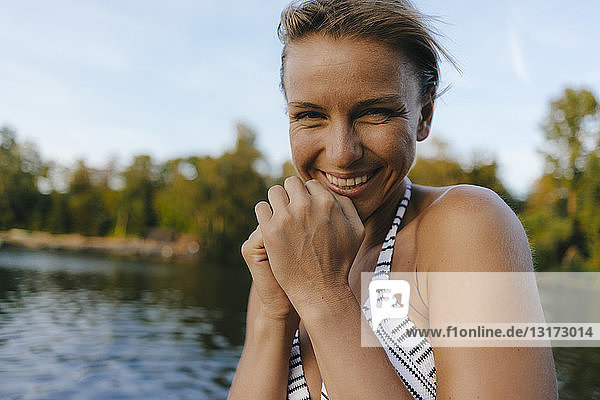 Porträt einer glücklichen Frau im Bikini an einem See